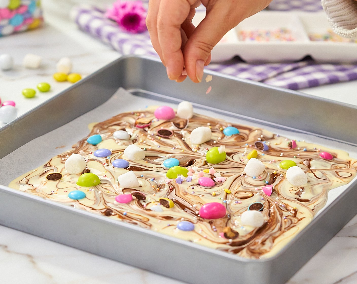 step 5 Sprinkle M&M's® Milk Chocolate Candy (4 Tbsp), Sprinkles (1 tsp), and Mini Marshmallows (5) on top of the melted chocolate. Chill in the freezer for at least 20 minutes or until firm to the touch.