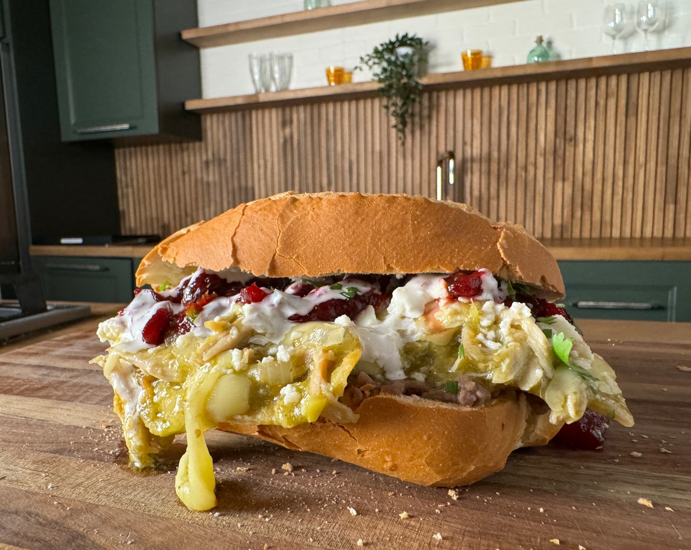 step 3 Assemble: Warm the Bolillo Rolls (4) and spread with a thin layer of Refried Beans (1 cup). Top with the chilaquiles, cranberry salsa, Mexican Crema (to taste), and Queso Fresco (to taste).