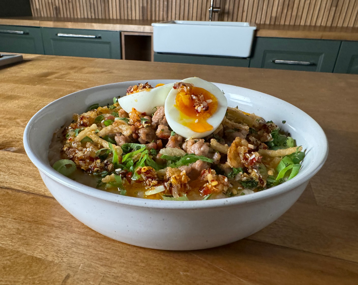 step 4 Assemble and Serve: Divide the congee into bowls. Top each bowl with cooked ground pork. Drizzle with chili crisp and add Scallions (to taste), Fresh Cilantro (to taste), Fried Shallots (to taste), and Hard-Boiled Eggs (to taste).
