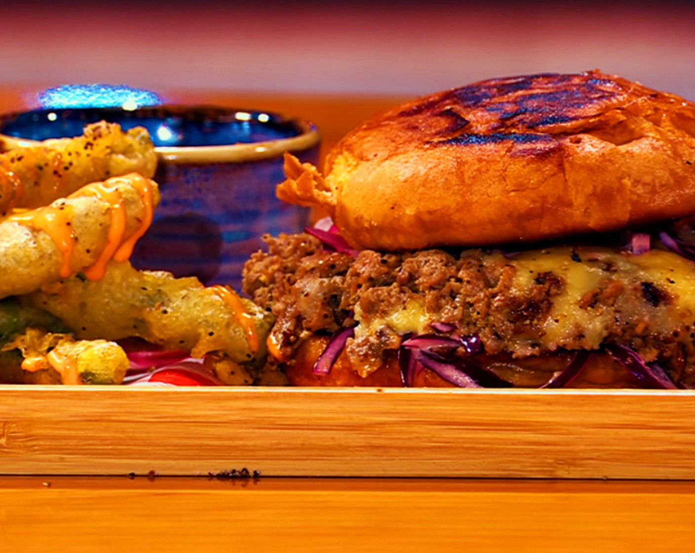 step 19 Top with caramelized onion and the fried egg. Lean the top of the brioche burger bun against the burger and serve with aioli dip and fried green beans.
