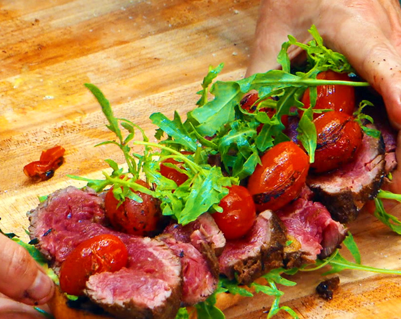 step 13 Assemble sandwich: Slice the filet and season with salt. Layer the sliced steak on the aioli and top with Arugula (to taste) and charred tomatoes. Serve open faced.